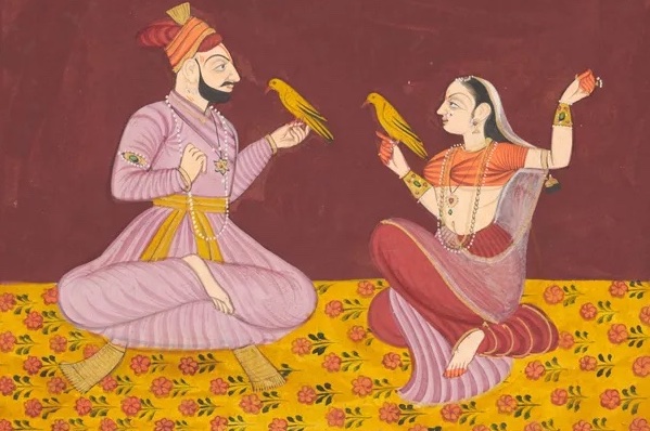 An Indian couple painted in the Mughal style sitting on a patterned cloth with birds in their hands.